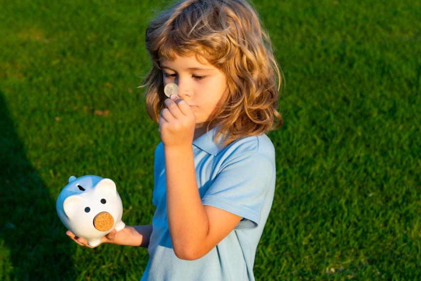 Kleines Mädchen mit Sparschwein in der Hand