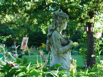 Diana blickt verträumt in den Garten und zum Gartenteich
