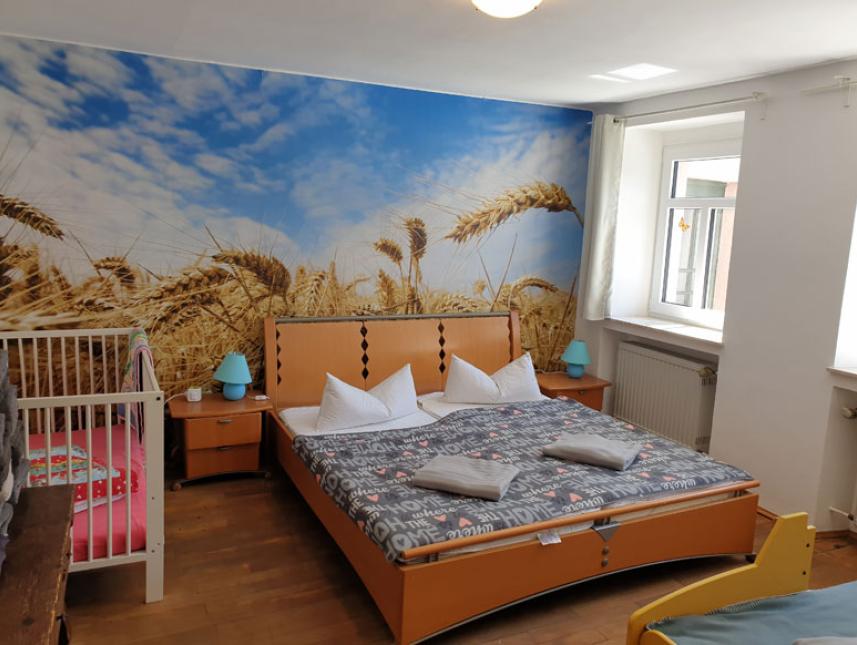 Schlafzimmer mit Doppelbett, Bett in Rennauto-Optik und Babybett