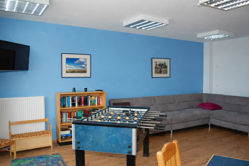 Unser Aufenthaltsraum mit gemütlichen Sofalandschaften, Tischkicker & Kinderecke