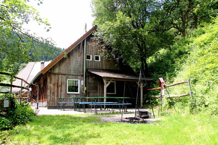 seperate Terrasse mit überdachtem Holzkohlegrill und kleiner Feuerstelle