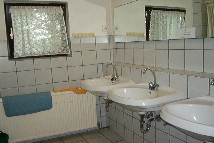 Zwei Bäder mit je drei Waschbecken und zwei Duschen