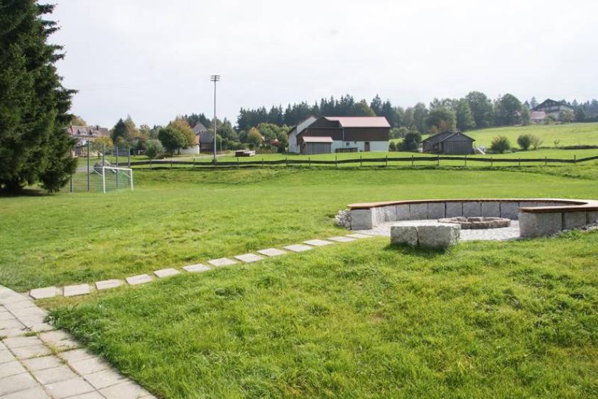 Wiese mit Fußballtoren und Lagerfeuerplatz