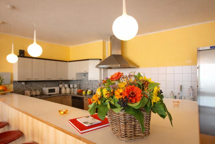 Die offene Küche mit großem Gasherd und viele Kühlschränke.