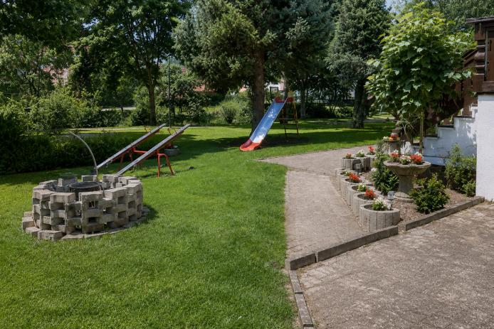 Garten hinter dem Haus mit Feuerstelle und Terrassen