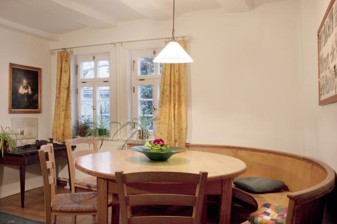 Im Wohnzimmer ist ein großer runder Tisch der ca. 10 Personen Platz bietet