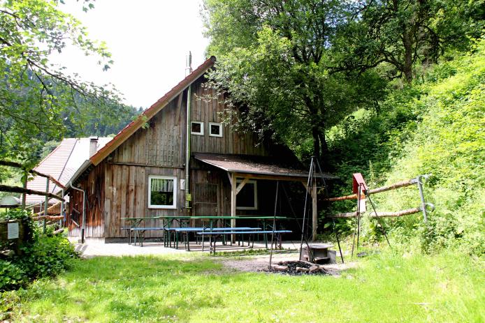 seperate Terrasse mit überdachtem Holzkohlegrill und kleiner Feuerstelle