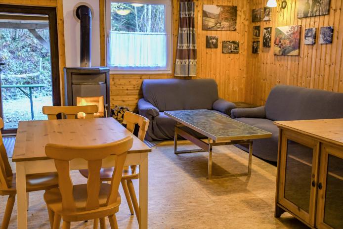 großer Aufenthaltsraum mit Sofaecke und Kaminofen