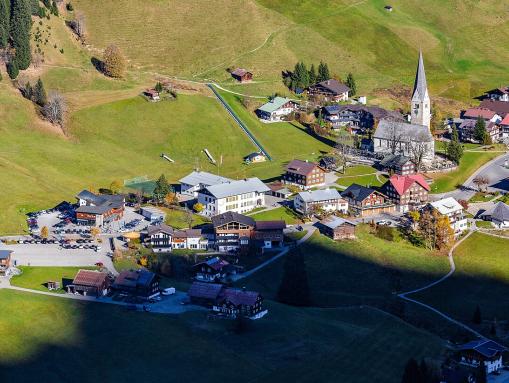 Luftbild vom Ortszentrum Mittelberg mit Talstation der Walmendingerhornbahn