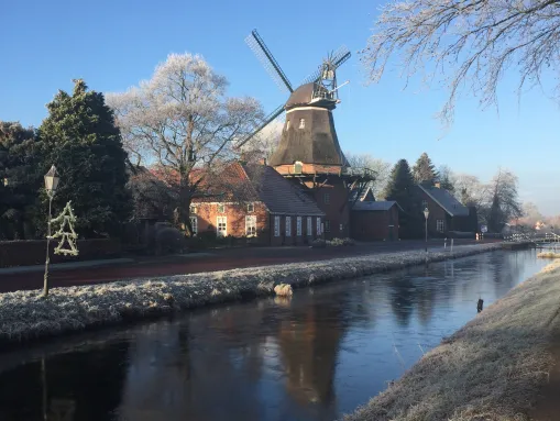 Die historische Windmühle Westgroßefehn und das Fehnmuseum Eiland an einem frostigen Wintermorgen.